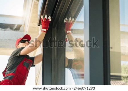 Construction technician working on fixing a window shutters. Construction industry theme.