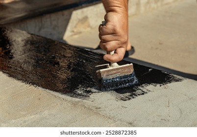 Construction techniques for waterproofing basement and foundations. Insulation material on the basement concrete wall. Waterproofing house foundation with spray on tar and roll waterproofing