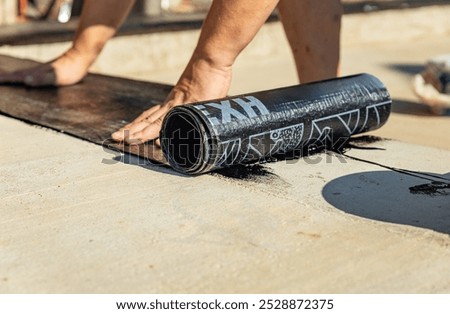 Construction techniques for waterproofing basement and foundations. Insulation material on the basement concrete wall. Waterproofing house foundation with spray on tar and roll waterproofing