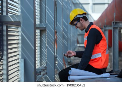 Construction Technology Concept. Engineer. Industrial Technology. Worker Using Phone In Plant In Industrial.