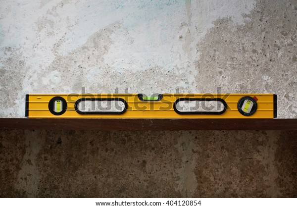 Construction tool Bubble spirit level on line at\
concrete background. Copy space for\
text