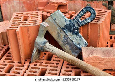Construction tool for laying bricks and blocks. Bricklayer's tools - hammer, spatula, trowel, gloves. Hand tools on the background of brickwork - Shutterstock ID 2235938177