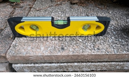 Construction tool on stone surface for measurement and alignment. A spirit level, bubble level.