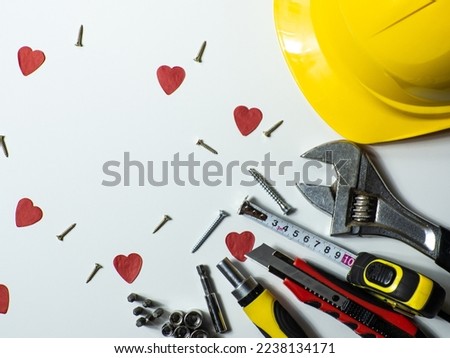Construction tools, hard hat on white background with small red hearts and copy space. Construction greeting card for Valentines day. Repair home with love. Gifts for lover. Buying presents for man.