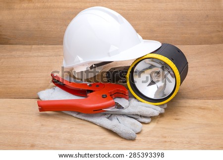 Construction tools on white background. Arrangement of hard hat, leather gloves and flashlight 