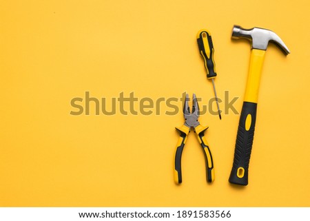Construction tools on the yellow flat lay background with copy space.