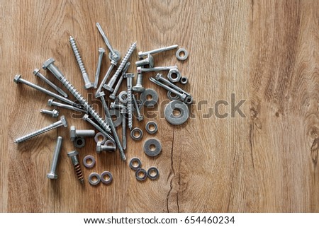 Construction tools. The screws, nuts and bolts on wooden background. Repair, home improvement concept. Free space for text, top view, flat lay.