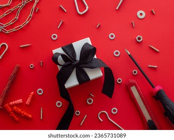 Construction tools and wrapped gift on red background. Construction greeting card for Christmas, Fathers, Mens or Valentines day. Repair home with love. Gifts for lover. Buying presents for man.