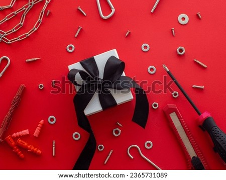 Construction tools and wrapped gift on red background. Construction greeting card for Christmas, Fathers, Mens or Valentines day. Repair home with love. Gifts for lover. Buying presents for man.