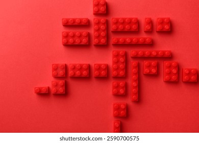 Construction toy. Building bricks on red background, flat lay