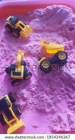construction toy in kinetic sand, purple background 