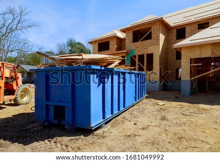 Construction trash dumpsters on metal container, house renovation.