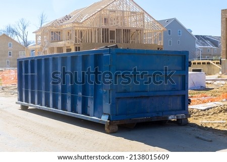 Construction trash dumpsters on metal container, house renovation.