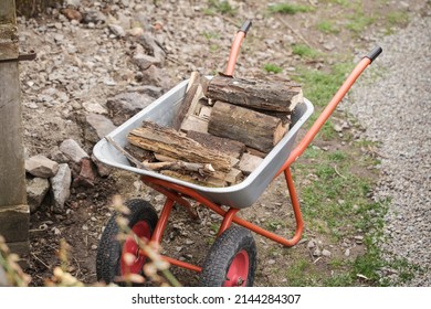 Construction Trolley With Logs In The Garden. Horticulture And Gardening Concept. Ecology Theme. Firewood For The Bath.