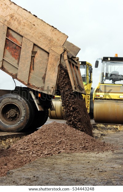 Construction truck unloads ground to the\
construction site and road\
widening.