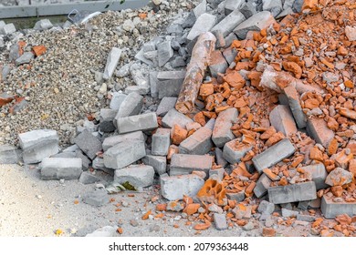 Construction waste. A pile of red broken bricks, concrete debris and rubble. Demolition rubble