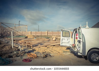 Construction Work Van With Door Open In The Back And Working Tools Inside Near Construction Site. Wood Frame House Project Foundation Framing In Irving, Texas, USA.