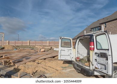 Construction Work Van With Door Open In The Back And Working Tools Inside Near Construction Site. Wood Frame House Project Foundation Framing In Irving, Texas, USA.