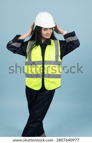 Construction worker adjusting hardhat helmet in studio in a professional phot...