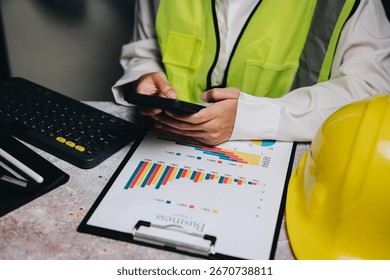 Construction Worker Analyzing Data on Tablet with Safety Gear and Reports in Office Environment. - Powered by Shutterstock - Get 15% off with code: PIKWIZARD15