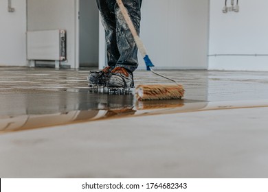 A Construction Worker Apply Epoxy Resin In An Industrial Hall