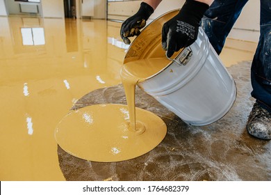 A Construction Worker Apply Epoxy Resin In An Industrial Hall