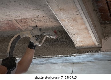 Construction Worker Applying Cement Plaster Between Concrete Beams With Plastering Machine