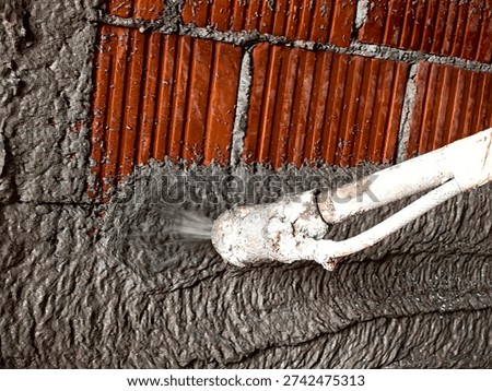 Construction worker applying cement plaster coating to a wall using a machine. Machine Plastering, process involves a plastering machine that sprays mortar onto surfaces to achieve a smooth and consistent finish. 