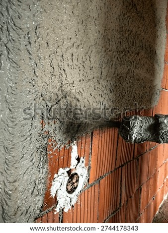 Construction worker applying cement plaster coating to a wall using a machine. Machine Plastering, process involves a plastering machine that sprays mortar onto surfaces to achieve a smooth and consistent finish. 