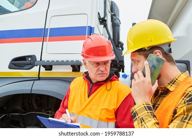 Construction Worker And Architect With Cellphone And Checklist In Front Of Truck On A Construction Site