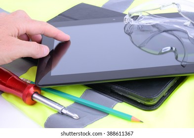 Construction worker and architect using a tablet computer on a site to communicate and design.