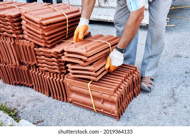 Construction Worker Arranging Batch Of Roof Tiles Unloaded From A Truck.