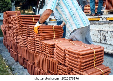 Construction Worker Arranging Batch Of Roof Tiles Unloaded From A Truck.