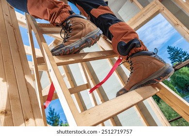 A construction worker ascends a wooden ladder, showcasing sturdy safety boots while surrounded by framing in bright sunlight. - Powered by Shutterstock