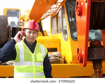 Construction Worker Calling With Hand Phone On Crane Truck