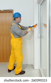 Construction Worker Caulking Door Or Window With Silicone Glue Using Cartridge