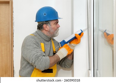 Construction Worker Caulking Door Or Window With Silicone Glue Using Cartridge