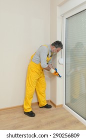 Construction Worker Caulking Door Or Window With Silicone Glue Using Cartridge