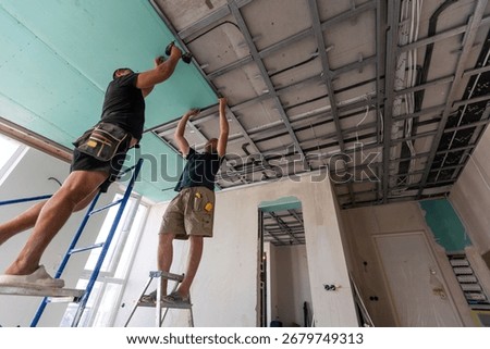 Construction worker ceiling work installation