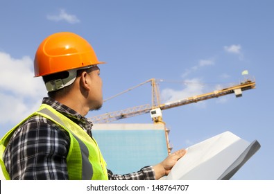  Construction worker checking the blueprints of a new building site