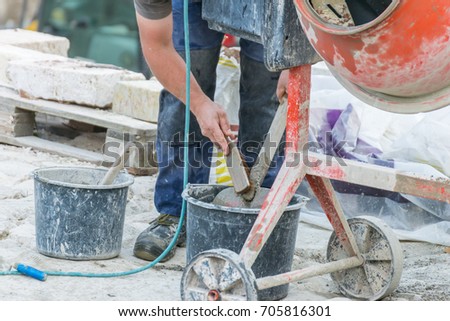 Construction worker is cleaning a shovel