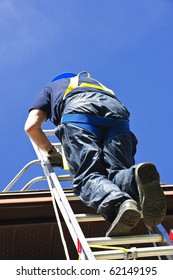 Construction Worker Climbing Extension Ladder To Roof