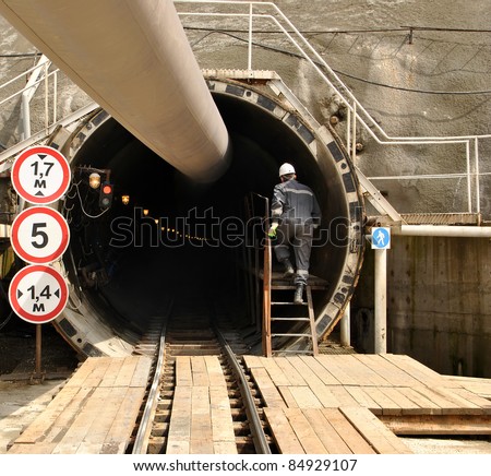 Construction worker climbs the stairs in the tunnel under construction. Technology adit tunnel complex combined rail and road to Krasnaya Polyana.