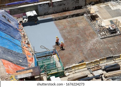 Construction Worker Coating Epoxy Spray Paint At Basement Floor Slab For Water Proof Protection.