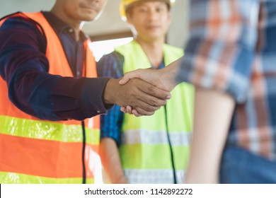 Construction Worker And Contractor. Client Shaking Hands With Team Builder In Renovation Site.