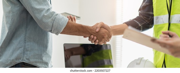 Construction Worker And Contractor. Client Shaking Hands With Team Builder In Renovation Site.