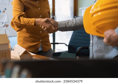 construction worker and contractor. Client shaking hands with team builder in renovation site