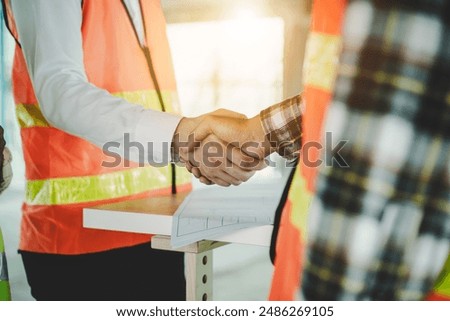 construction worker and contractor. Client shaking hands with team builder in renovation site.
