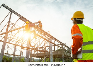 A construction worker control in the construction of roof structures on construction site and sunset background