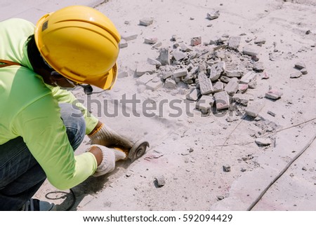 Construction worker  was Cutting  concrete in construction area.